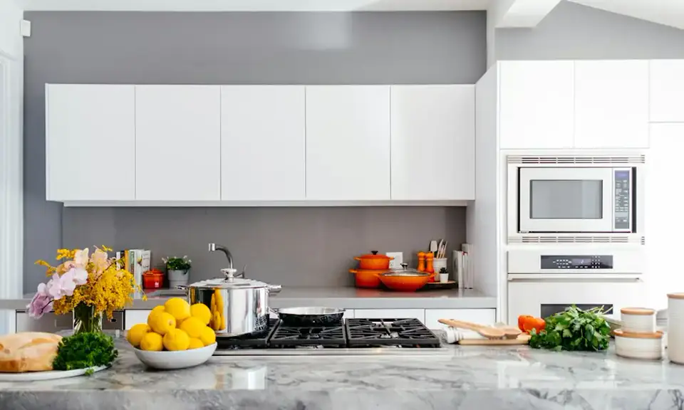 The kitchen: a marble island with stools, and open shelves of glasses and bowls