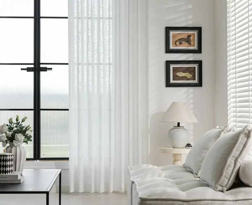 The living room: a long sofa, linen curtains and tall windows